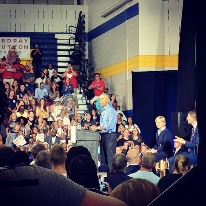 Barack Obama speaking at podium in Cleveland school gymnasium 