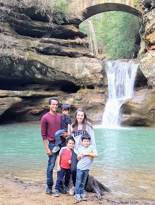 Family poses in front of waterfall at Hocking Hill State Park