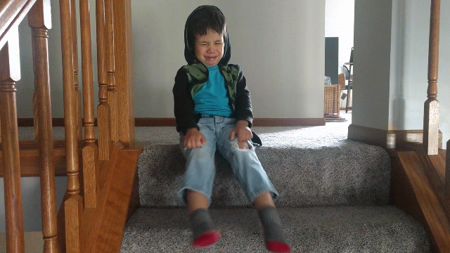 angry toddler kicking his legs on stairs