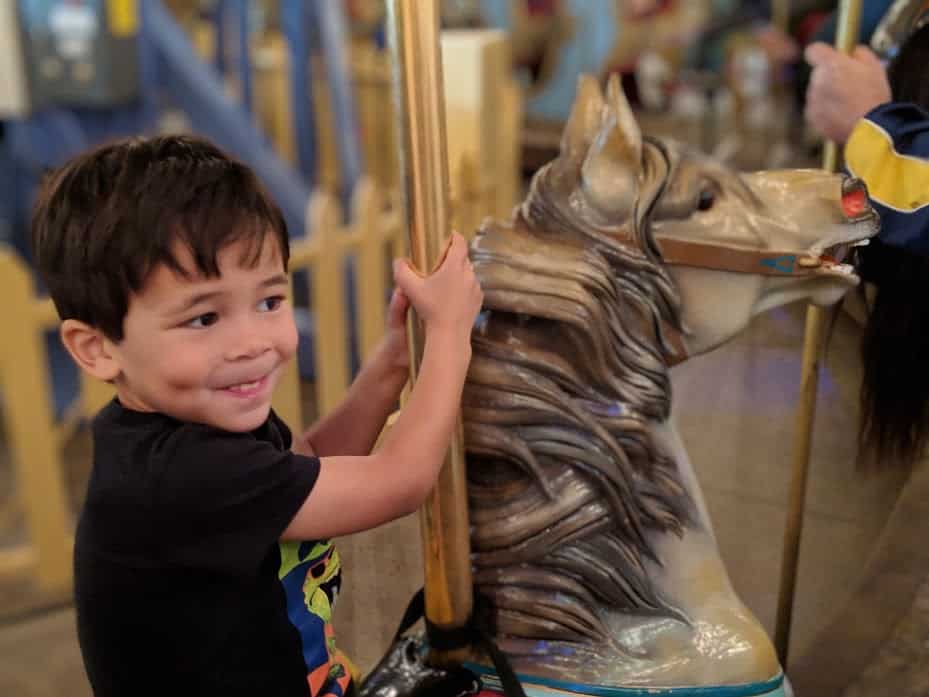 kid riding carousel at Children's Museum of Indianapolis