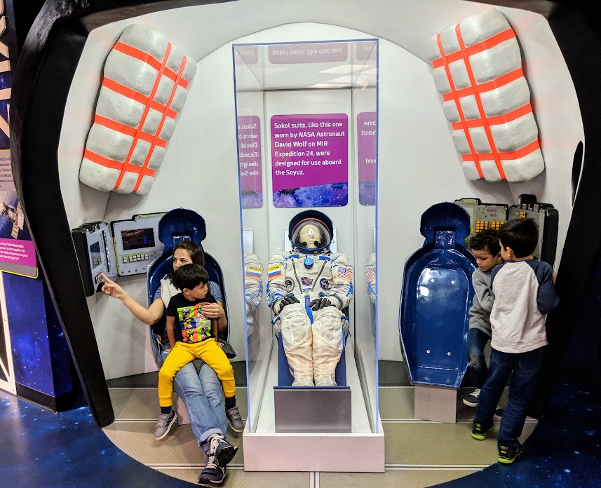 family playing in the space exhibit at the Children's Museum of Indianapolis