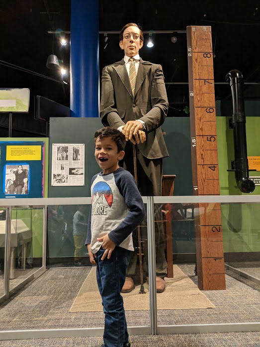 Kid stands in front of a replica of Robert Wadlow, world's tallest man. As seen in the Ripley's Believe It Or Not exhibit at the Children's Museum of Indianapolis. 