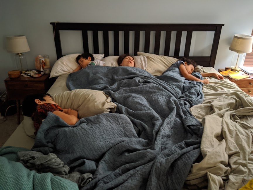 Mother with three kids taking over the king size bed. which has become part of our COVID-19 family routine.  