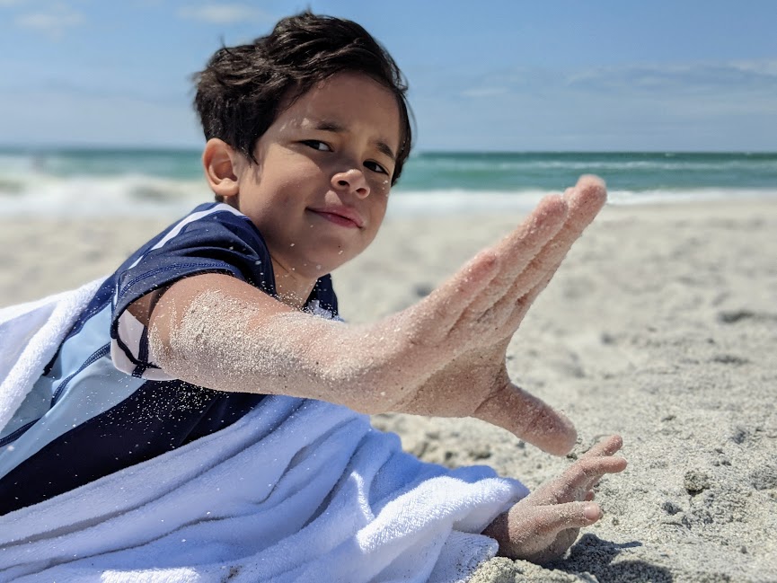 sand flying off kids hand at tampa beach