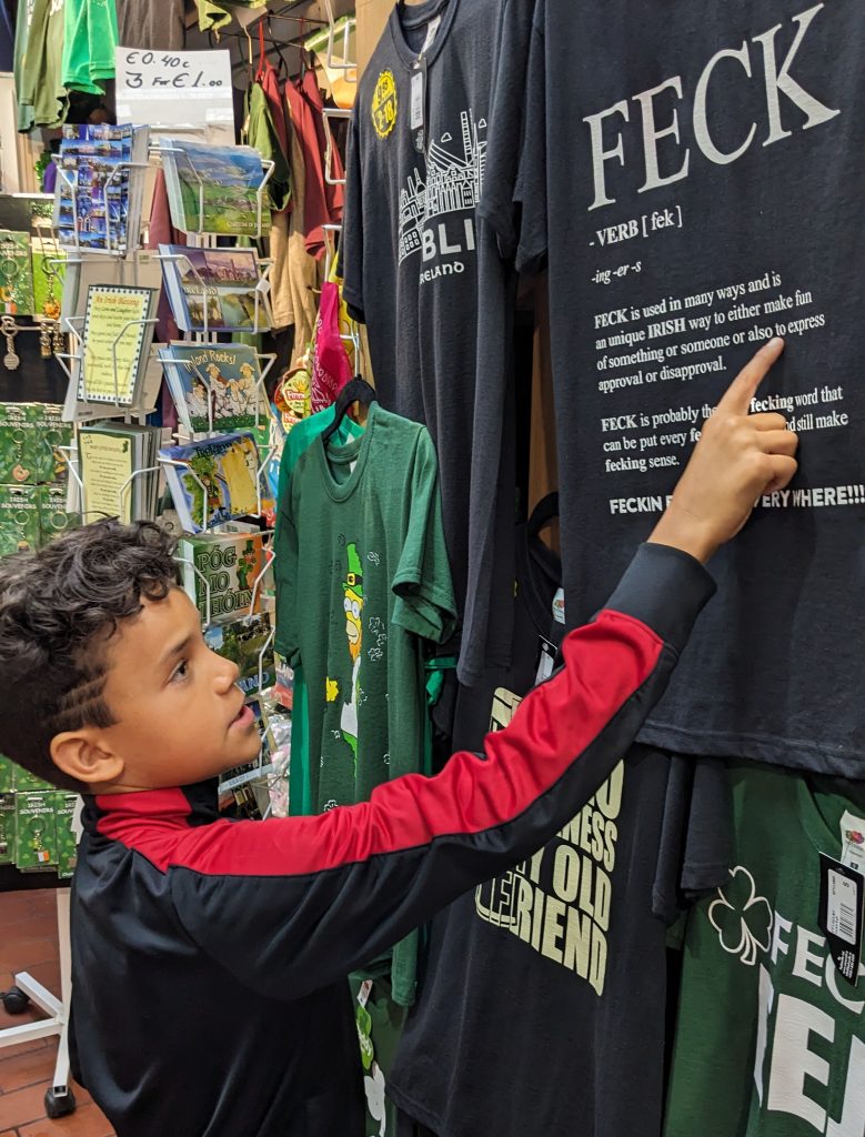 boy looking at t-shirt that reads "Feck" in Dublin, Ireland. 