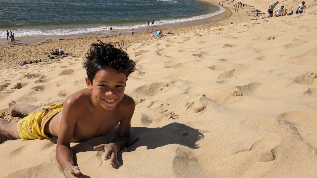 kid smiling and playing in the sand at dune du pilat in France