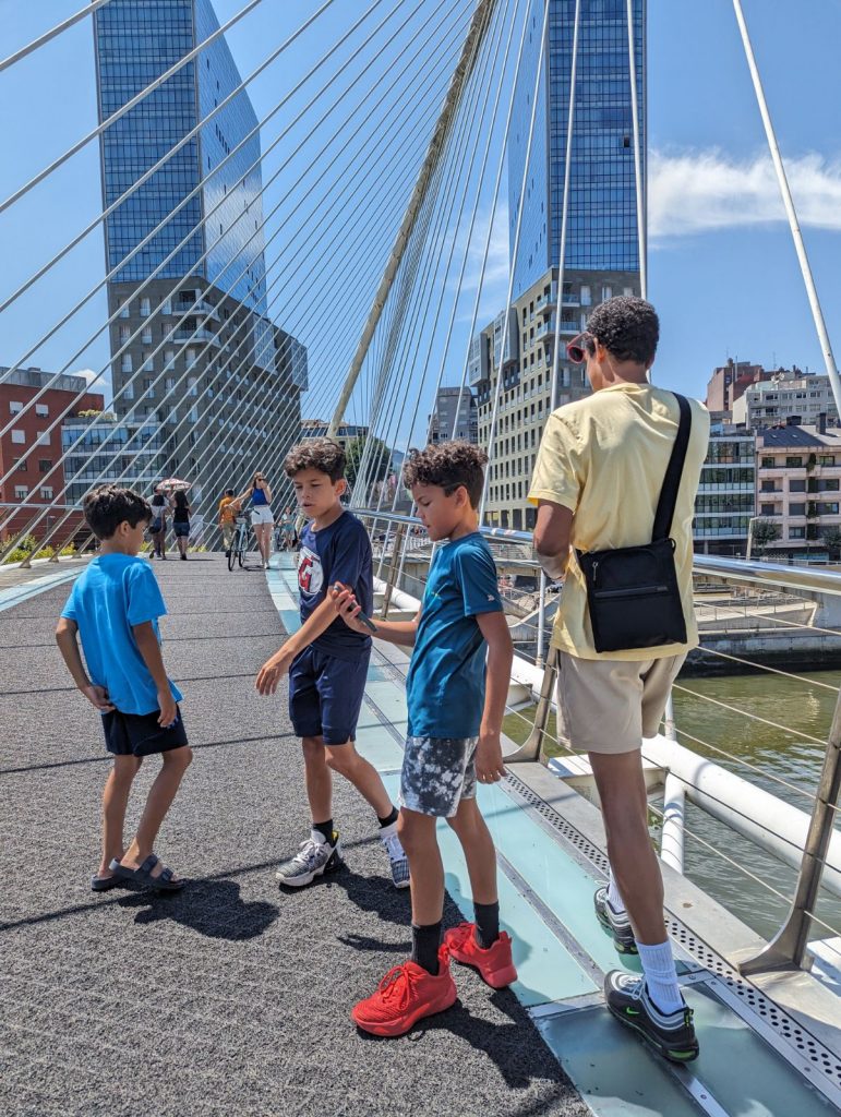 The author and his kids walking Zubizuri Bridge in Bilbao, Spain